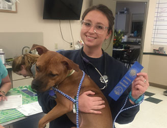 photo of Staff showing off a blue ribbon pet